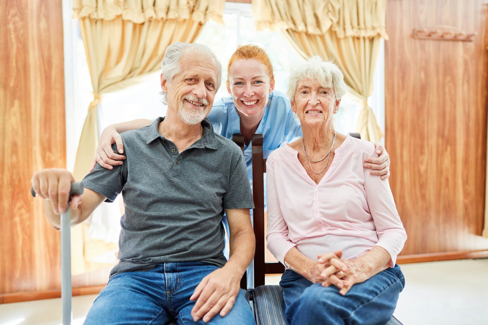 A woman and two elderly people sitting on a chair.