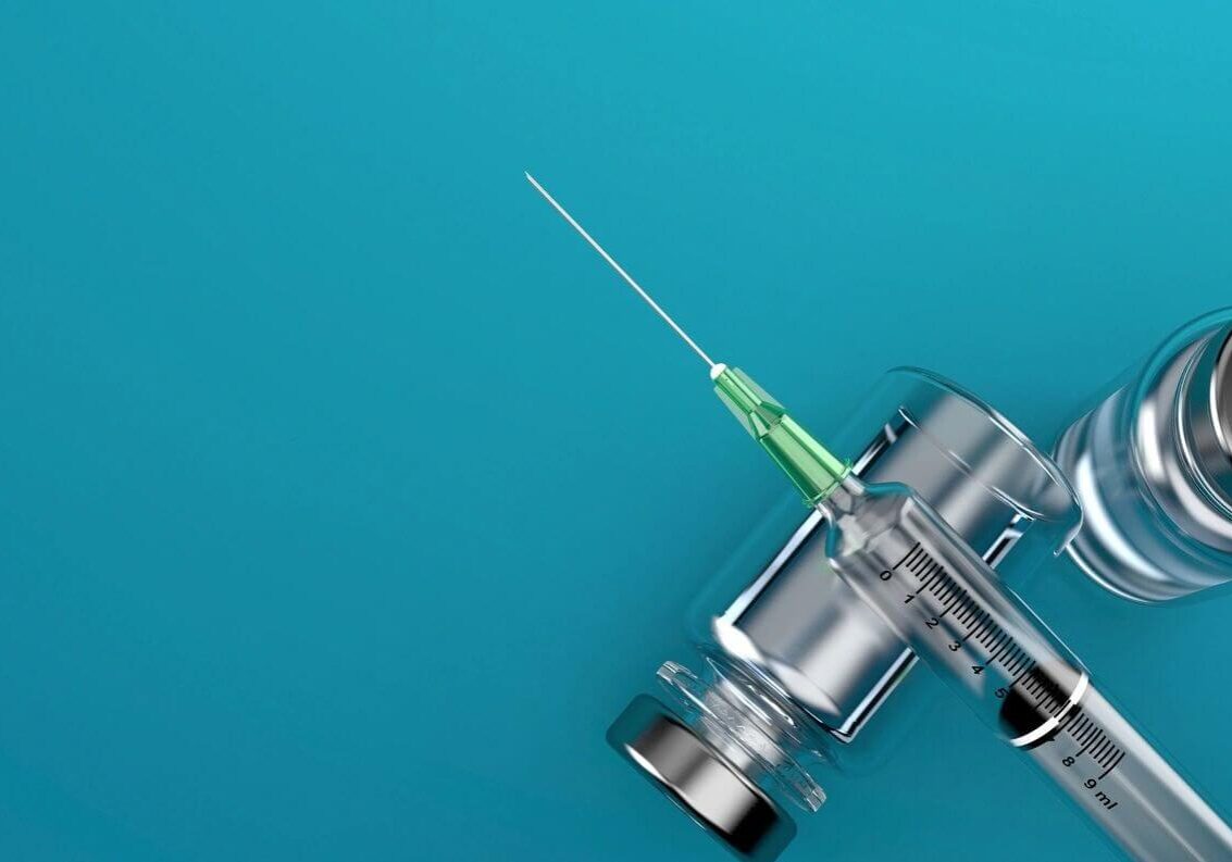 A green needle is sitting on top of a microscope.