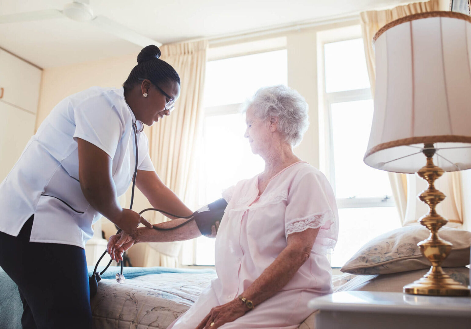 A nurse is checking the blood pressure of an older woman.